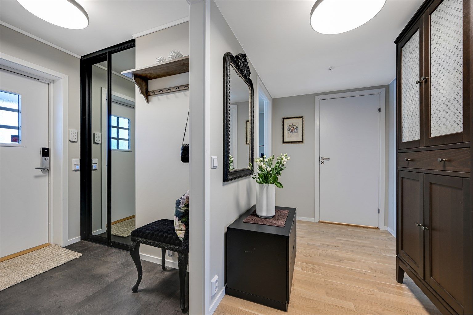 Inngangspartiet leder inn til et koselig vindfang med garderobeskap og videre til en mellomgang.