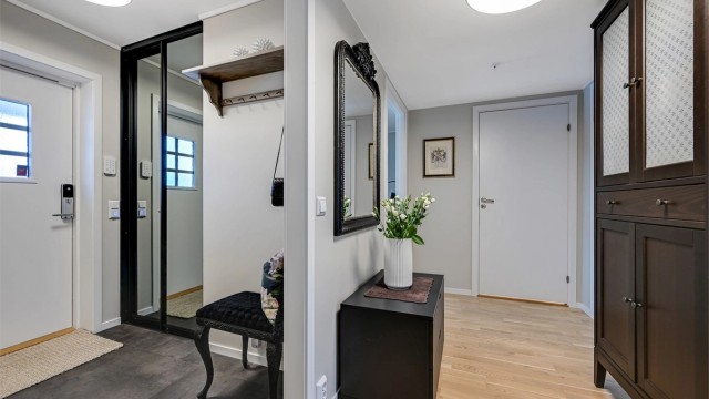 Inngangspartiet leder inn til et koselig vindfang med garderobeskap og videre til en mellomgang.