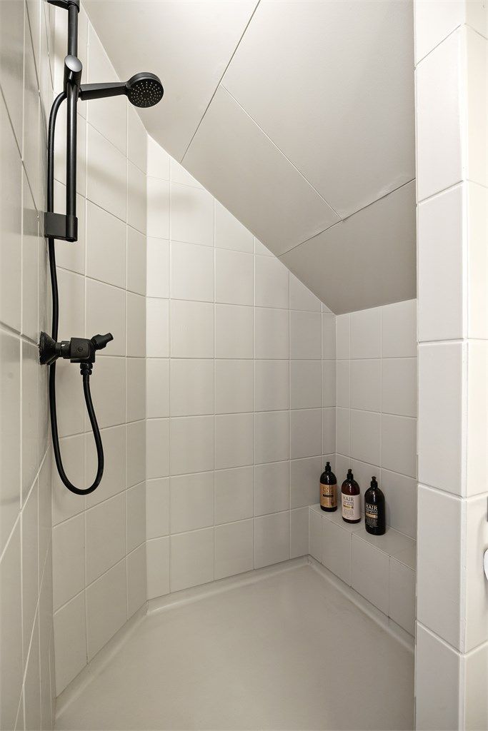 Badet er utstyrt med gulvstående toalett (2025) og dusjnisje med veggmontert dusjarmatur. 