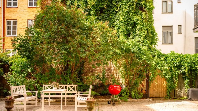 Pent opparbeidet bakgård med blant annet med belegningsstein, sittegruppe, felles grill og sykkelparkering.