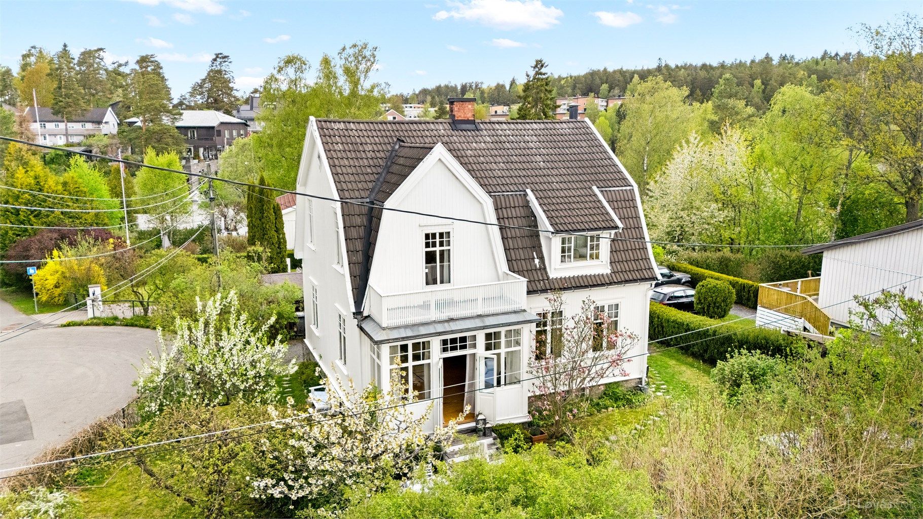 Oversikt over eiendommen og den grønne, frodige hagen.