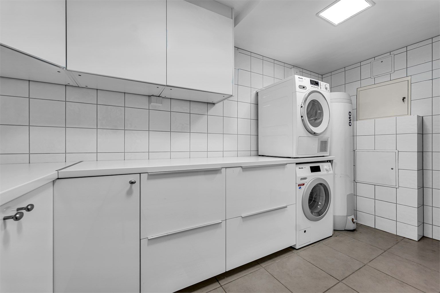 Separat og praktisk vaskerom med benkeplass og opplegg for vaskemaskin.