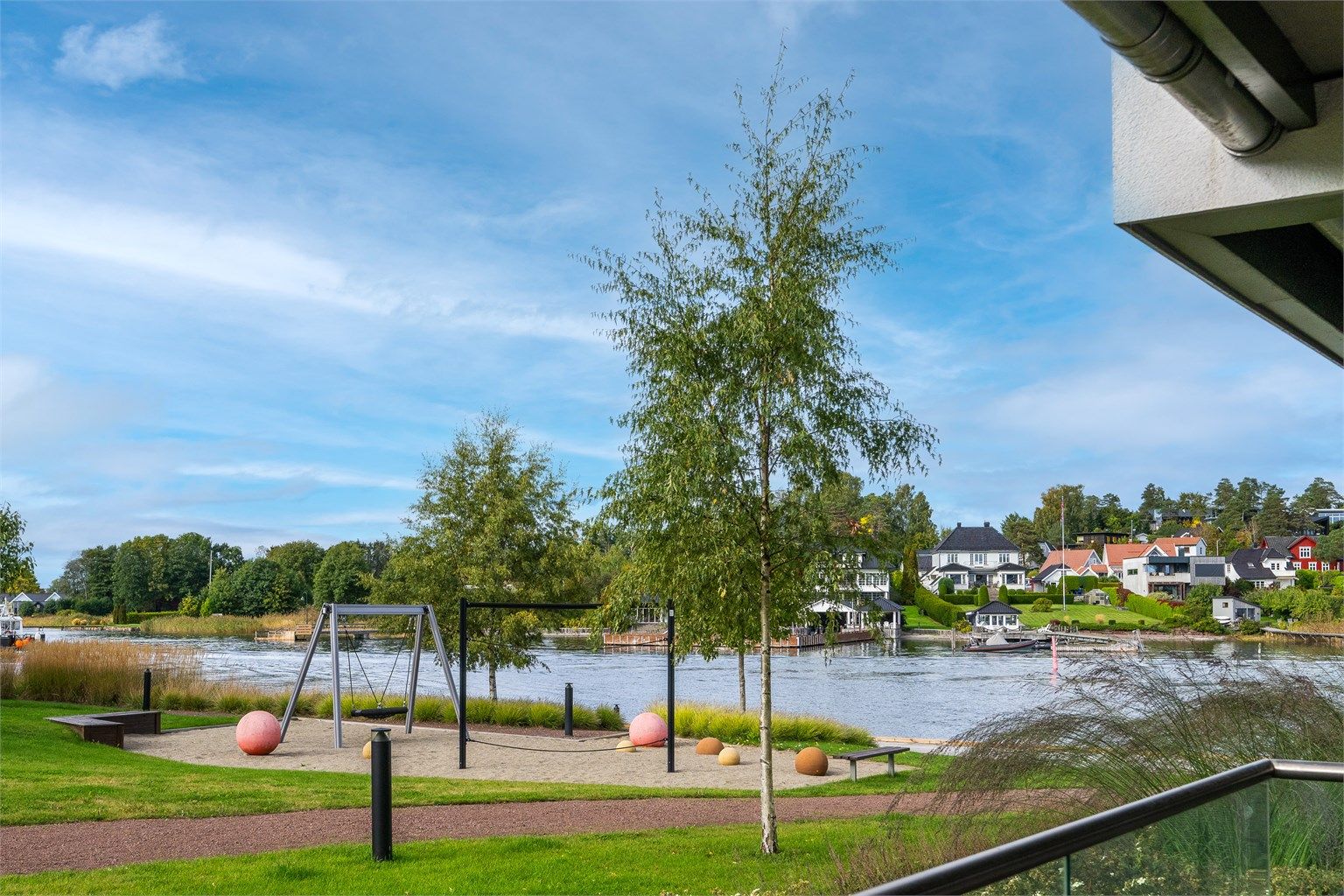 Utsyn fra terrassen mot lekeplassen, fellesområdene og Husøysundet.