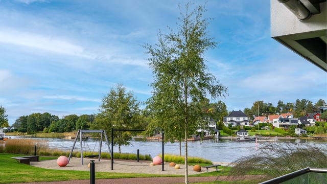 Utsyn fra terrassen mot lekeplassen, fellesområdene og Husøysundet.