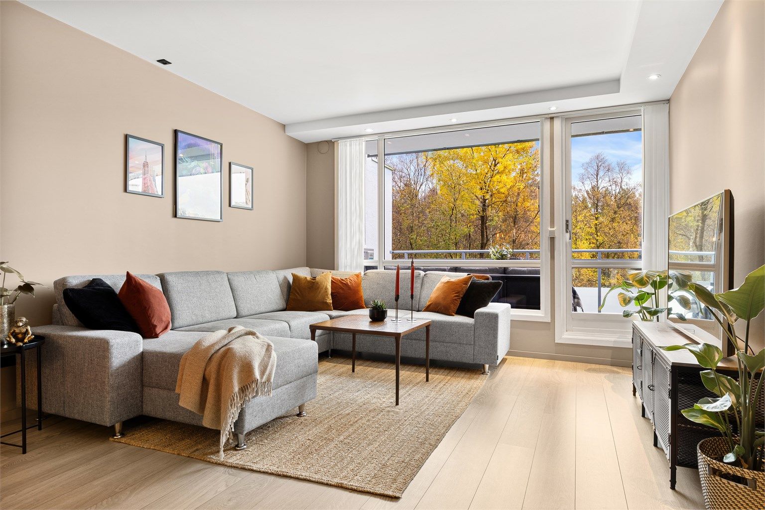 Leiligheten fremstår innbydende og moderne med lyse overflater og store vinduer som sørger for godt lysinnslipp