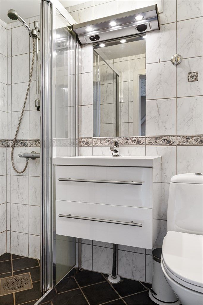 Badet i underetasjen har flislagt gulv med gulvvarme, dusjnisje, toalett og servant