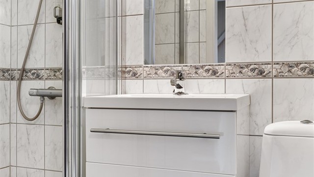 Badet i underetasjen har flislagt gulv med gulvvarme, dusjnisje, toalett og servant