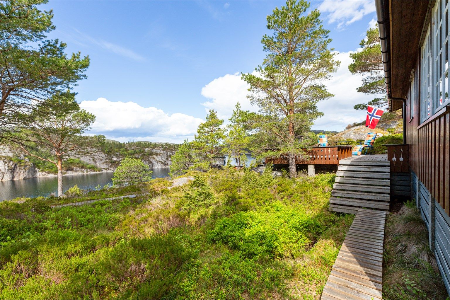 Pent opparbeidet naturtomt på 988,5 kvm med trapper og stier bygget i treverk og terrasse på terreng.