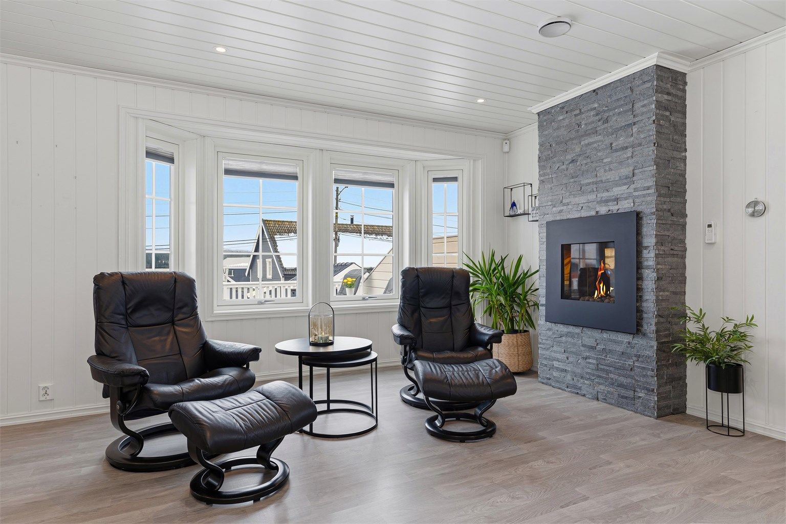 Superkoselig plass i stua foran gasspeisen med fin innsyn til flammene, dekorativ omramming med skiftersteinsforblending