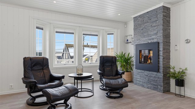 Superkoselig plass i stua foran gasspeisen med fin innsyn til flammene, dekorativ omramming med skiftersteinsforblending