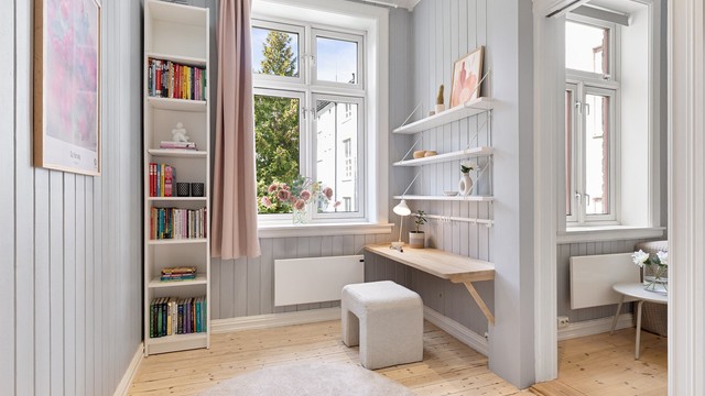 En praktisk arbeidsplass er etablert ved vinduet, med godt dagslys.