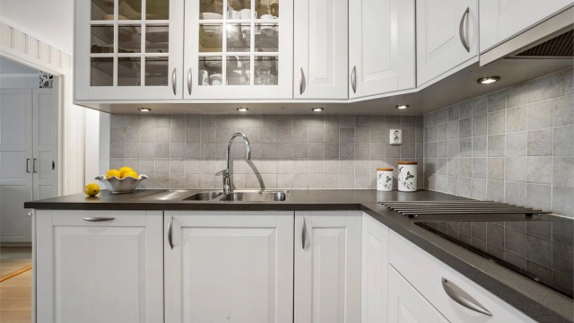 Fliser mellom benkeplate og overskap, samt praktisk belysning under overskap.