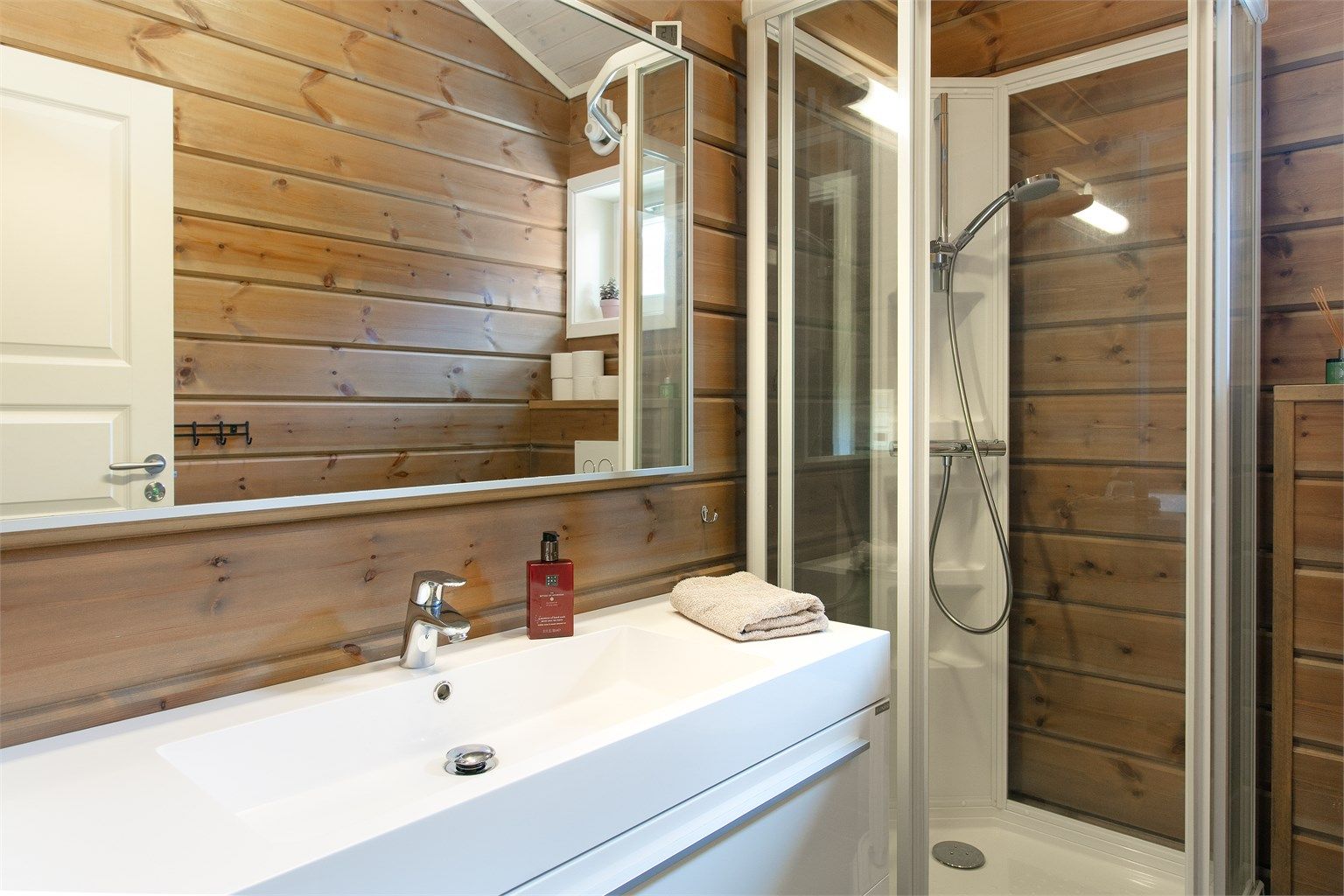 Detaljer fra badet, med heldekkende servant og godt med oppbevaringsplass.