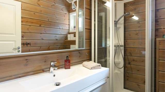 Detaljer fra badet, med heldekkende servant og godt med oppbevaringsplass.