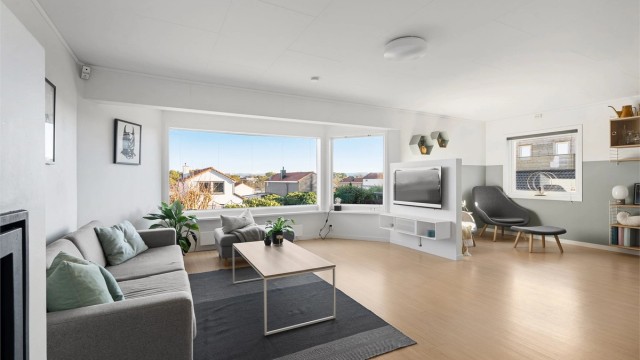 Stuen oppleves som meget lyst og luftig med store vindu, parkett på gulv og malte veggflater.