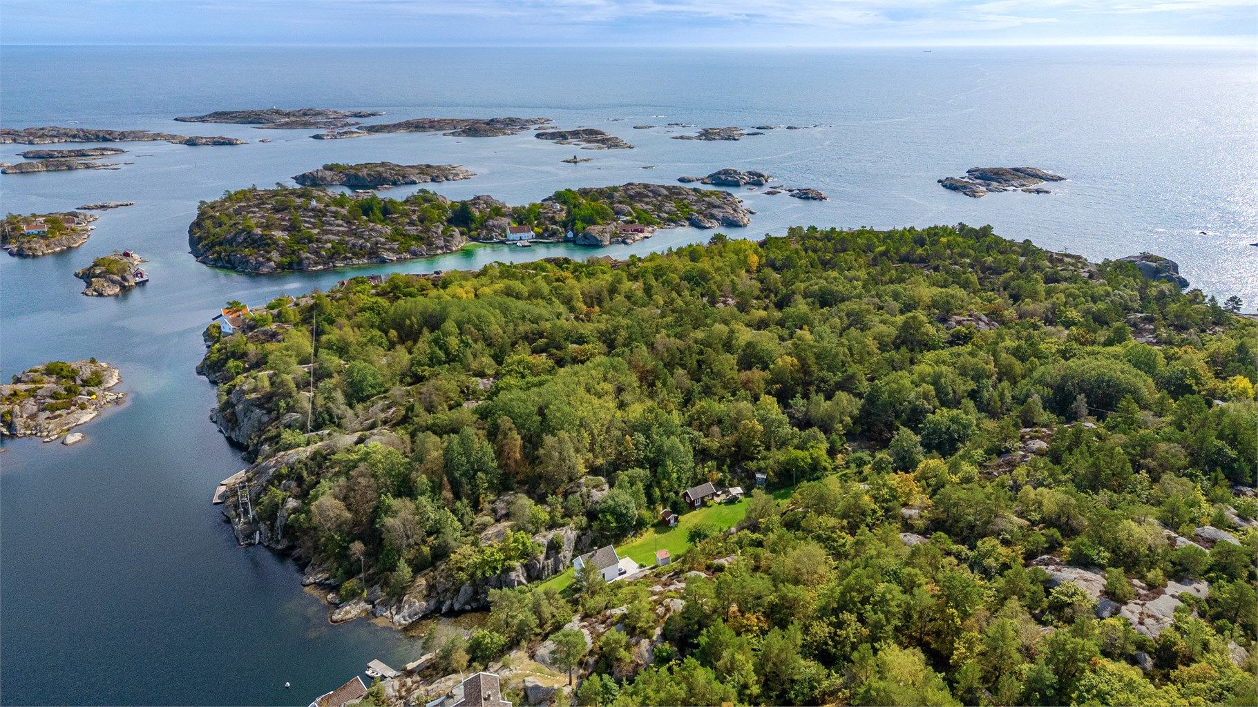 Eiendommen ligger omgitt av frodig natur, svaberg og et vakkert kystlandskap.