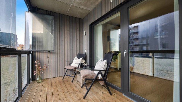 Innglasset terrasse på 8 m² som forlenger stuen og gir et lunt uterom.