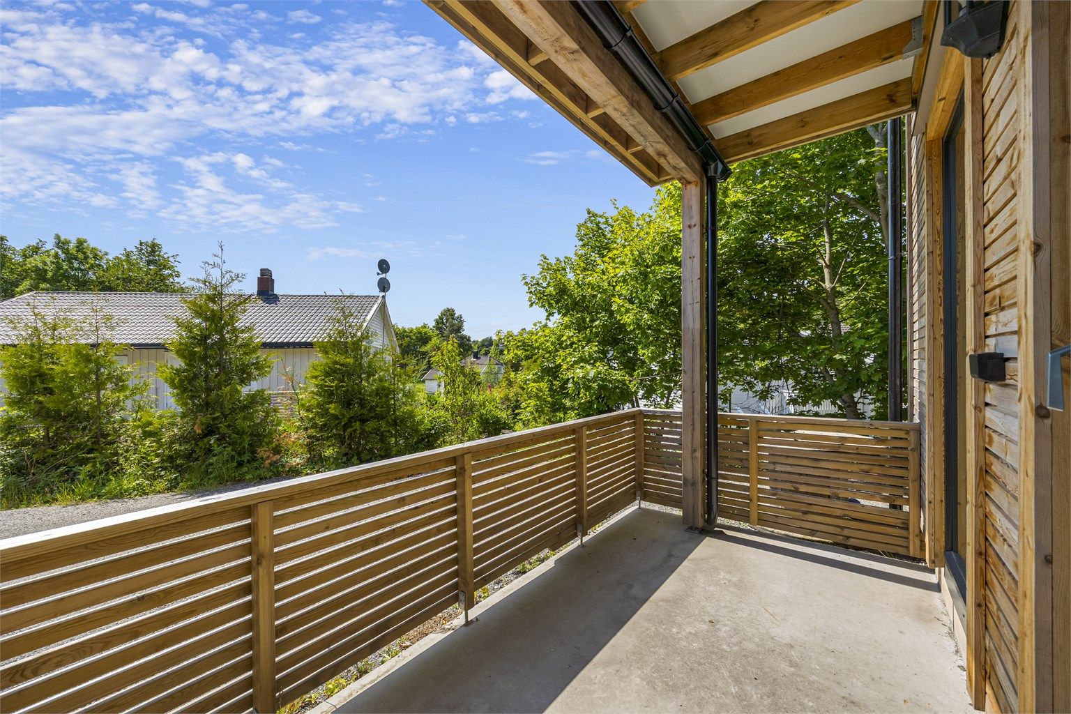 Terrassen på 11 m² er utført i betong og behandlet tre, og gir en fin, privat uteplass.