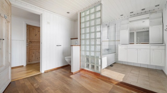 Innredningen består av et vegghengt servantskap med heldekkende servant, ett-greps armatur, speil med overlys og praktisk skapplass.