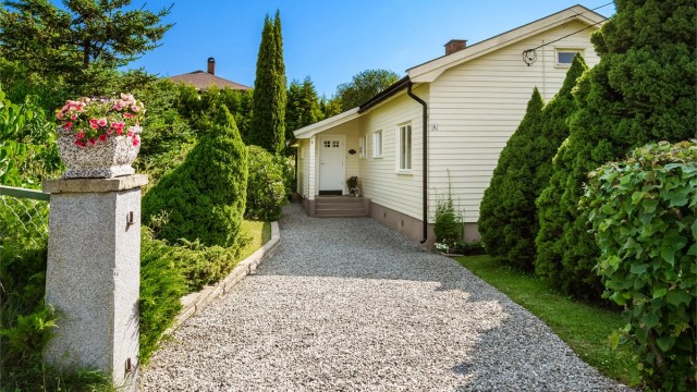 Gruset adkomstvei til boligens overbygde inngangsparti i 1. etasje.