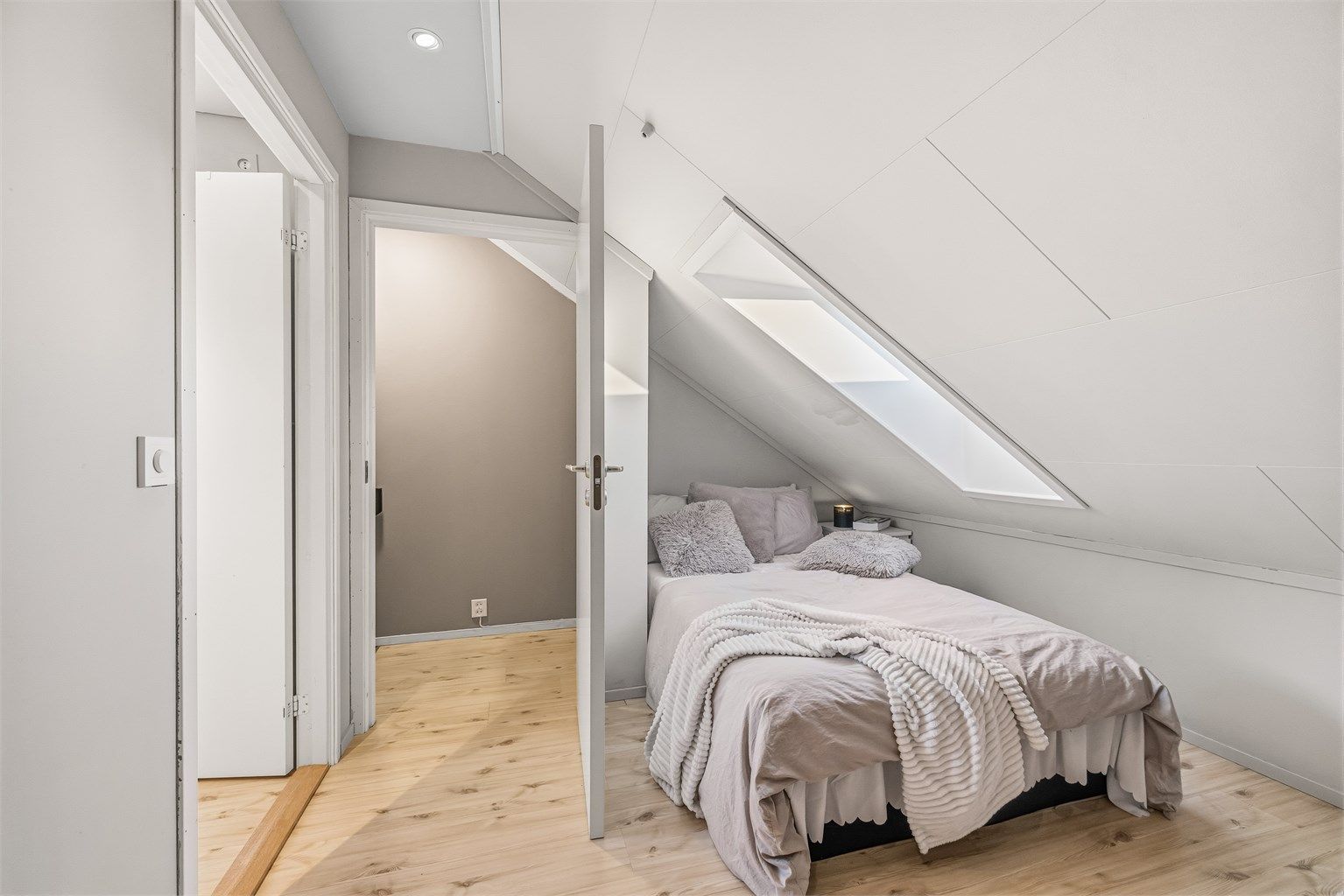 Det andre innredede rommet på loftet. Rommene har laminatgulv og platekledning i skråtak.