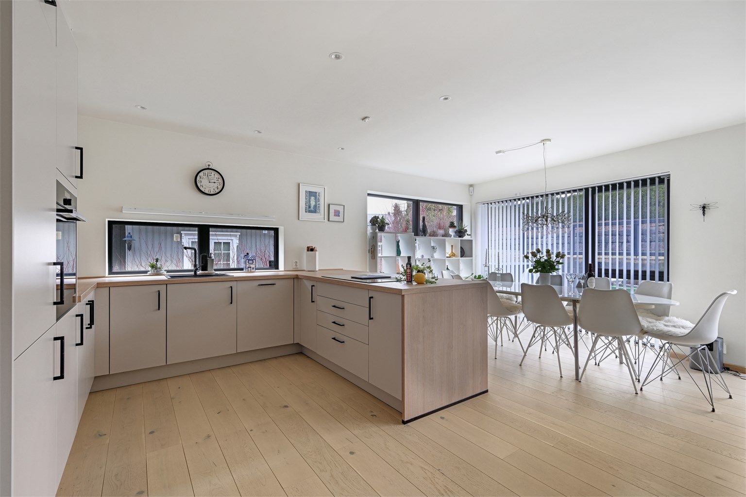 Den åpne løsningen gir en sosial og luftig atmosfære, med god plass til både spisebord og sofagruppe.