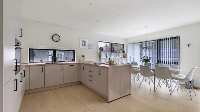 Den åpne løsningen gir en sosial og luftig atmosfære, med god plass til både spisebord og sofagruppe.