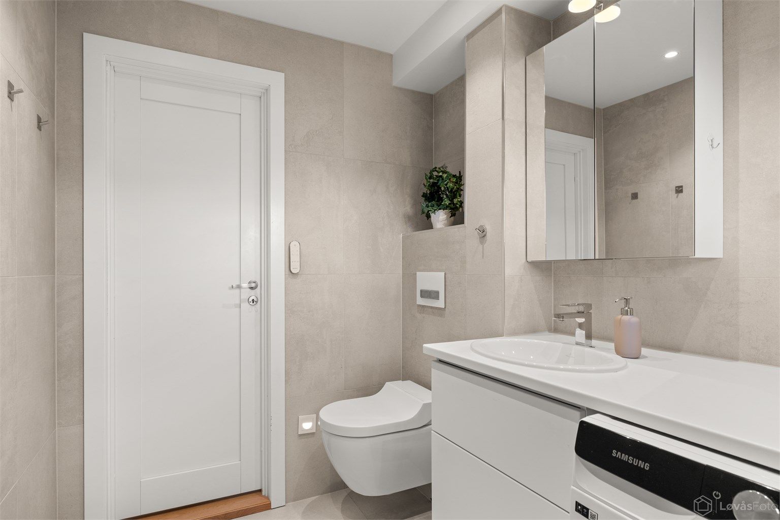 Vegghengt toalett og servantinnredning gir et stilrent uttrykk. Varmtvannsberederen er fra 2021.