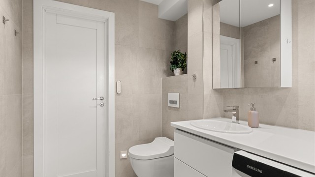 Vegghengt toalett og servantinnredning gir et stilrent uttrykk. Varmtvannsberederen er fra 2021.