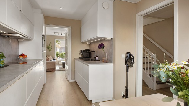 Stort og flott kjøkken med moderne hvite fronter, og laminert benkeplate med innfelt servant