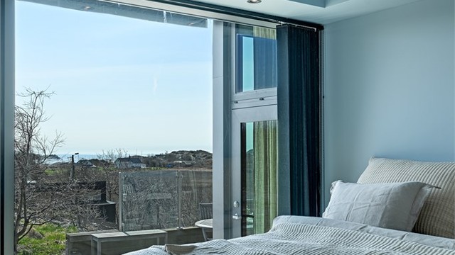 Fra sengen kan du nyte utsikten mot landskapet og havet