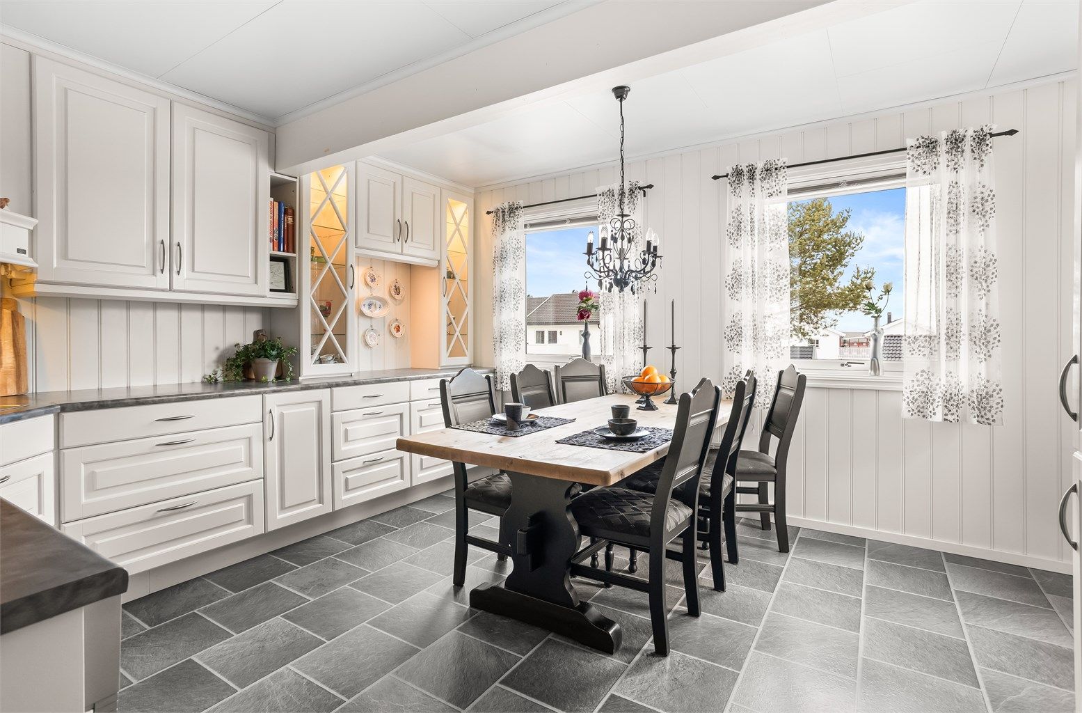 Kjøkkeninnredning fra 2007/2008 med hvite profilerte fronter og laminert benkeplate.