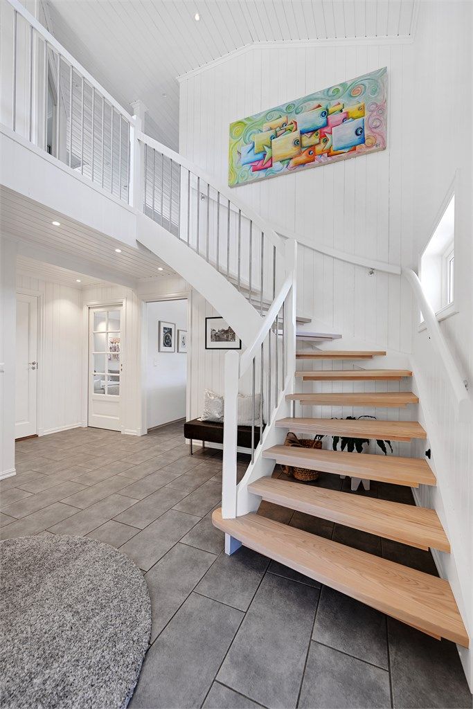 Den malte tretrappen med trinn i lakkert ask binder de to etasjene elegant sammen.