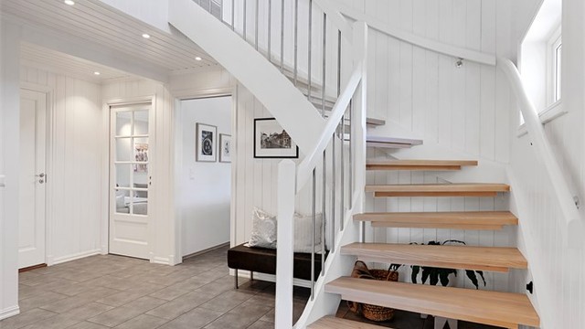 Den malte tretrappen med trinn i lakkert ask binder de to etasjene elegant sammen.
