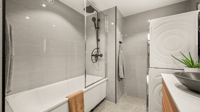 Det lekre badet ble oppgradert i 2022 og har badekar med både hånd- og regndusj. Flisvalget er stilrent og moderne.
