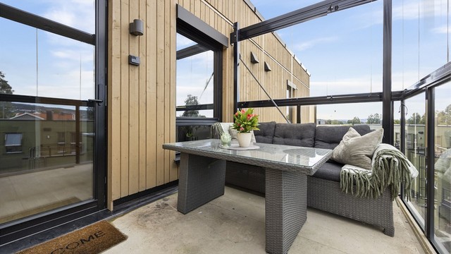 Innglasset balkong med gode møbleringsmuligheter for utendørs sittegruppe.