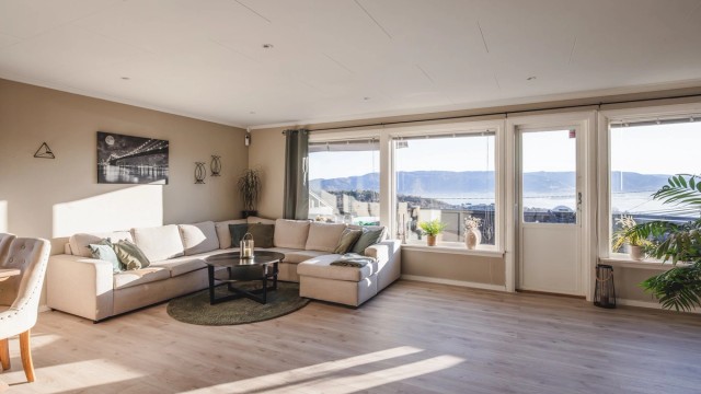 Lys og innbydende stue med adkomst til stor og solrik altan. Majestetisk utsikt fra stuen over hele Bergen sentrum og byfjorden.