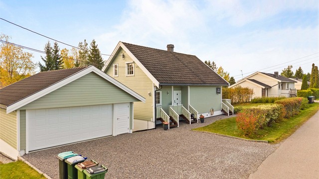 Romslig, singelbelagt gårdsplass med dobbelgarasje.