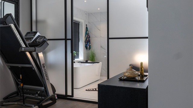 Bad og soverom er elegant adskilt med glassvegger, noe som gir et moderne og eksklusivt uttrykk.