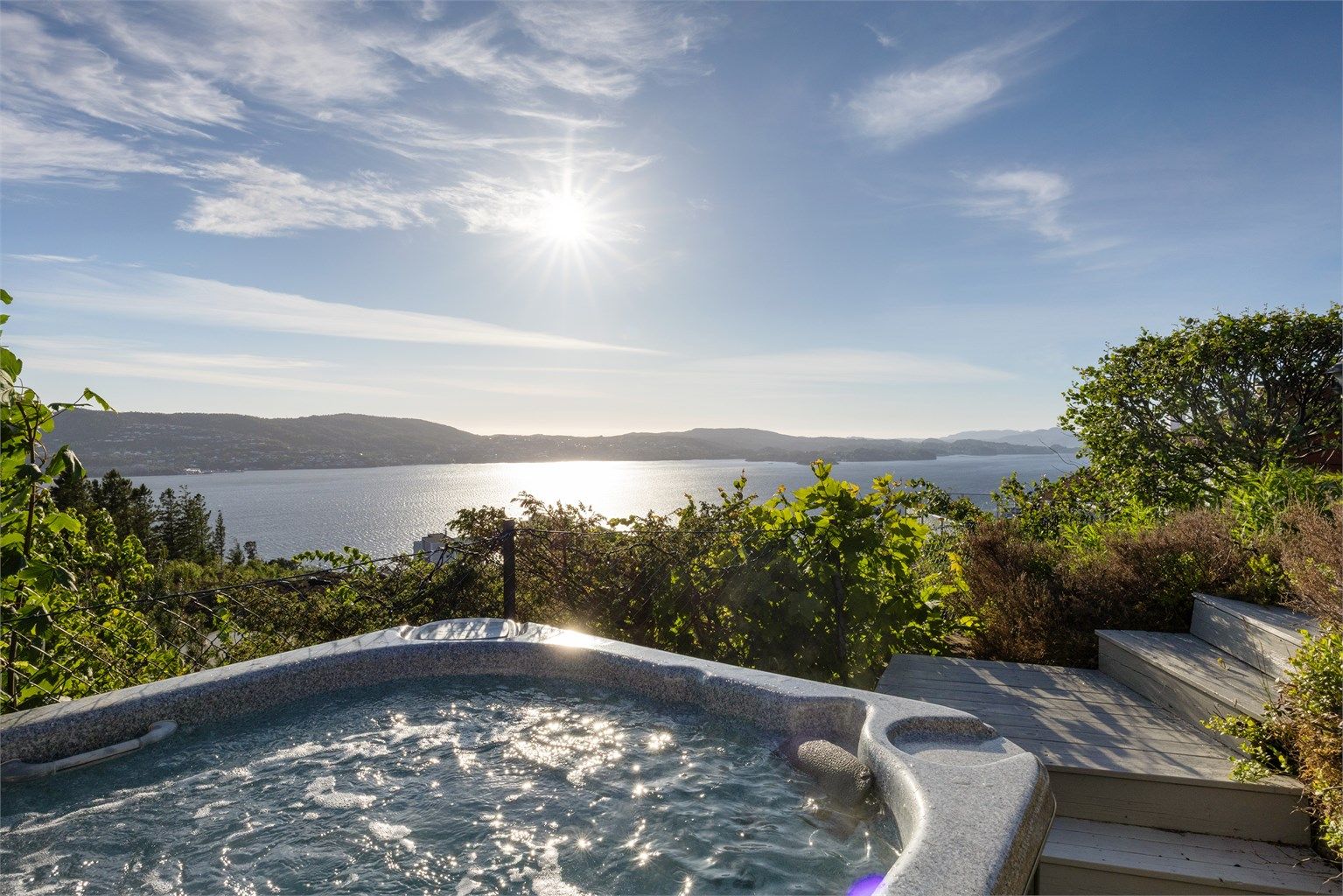 Jacuzzien er strategisk plassert ytterst mot utsikten - her kan du lene deg tilbake og nyte både panoramautsikt og spektakulære solnedganger.