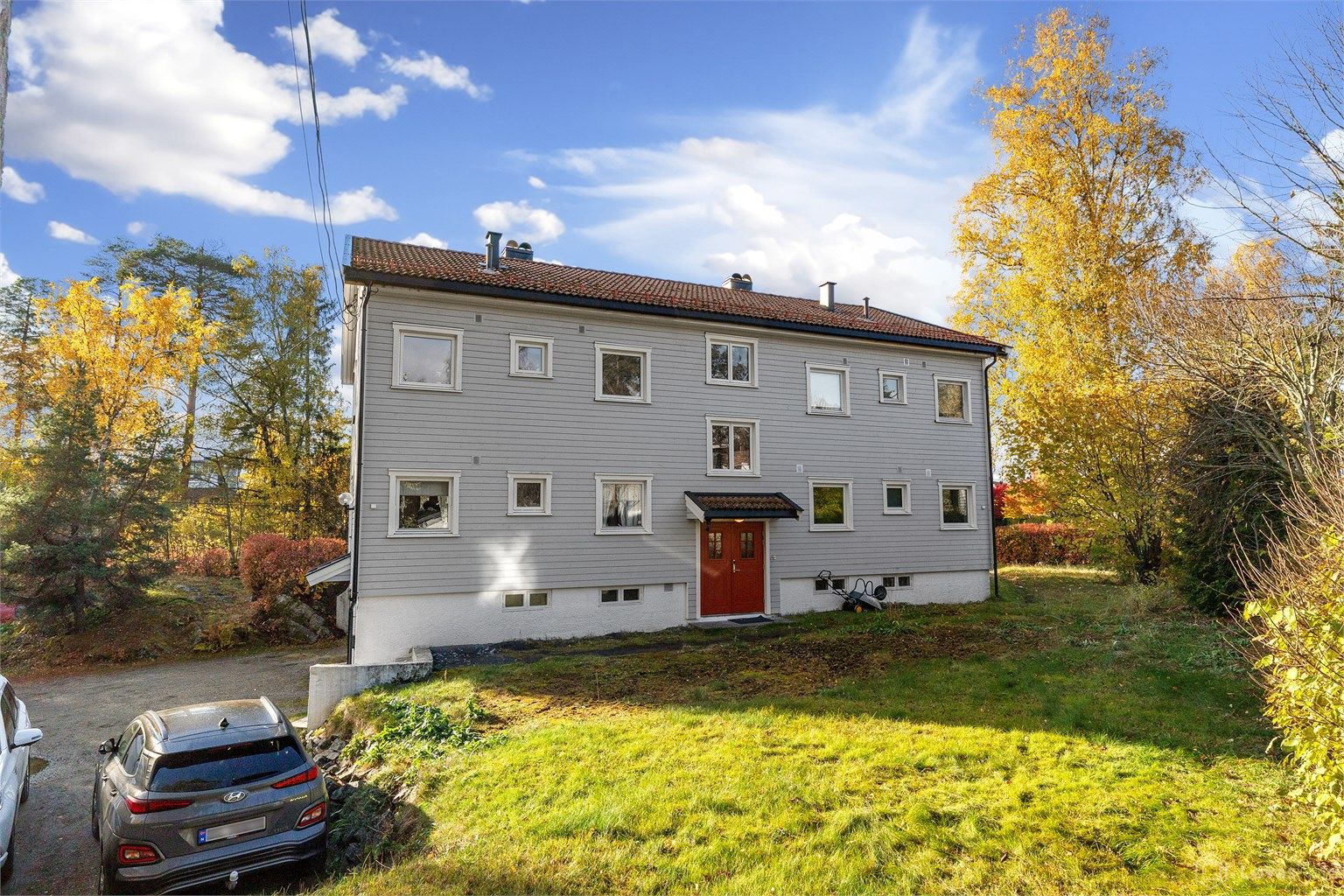 Adkomst via felles inngangsparti med gruslagt biloppstillingsplass og elbillader.