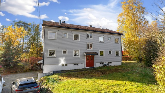 Adkomst via felles inngangsparti med gruslagt biloppstillingsplass og elbillader.