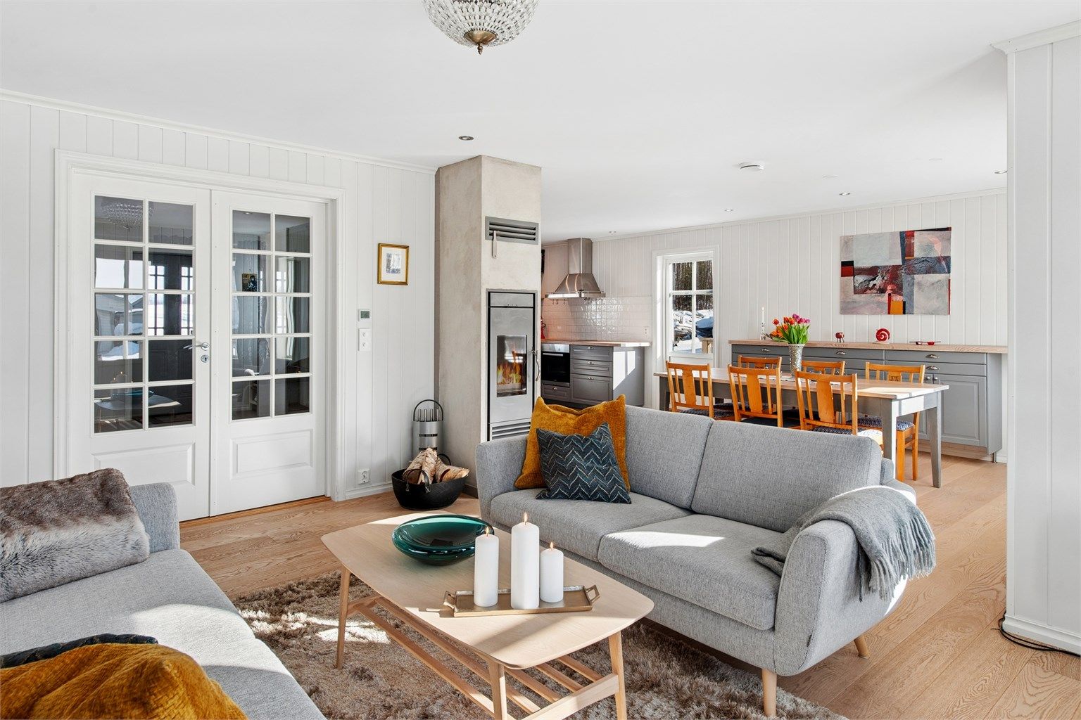 Et sosialt oppholdsrom med god soneinndeling og en lekker peisovn. 