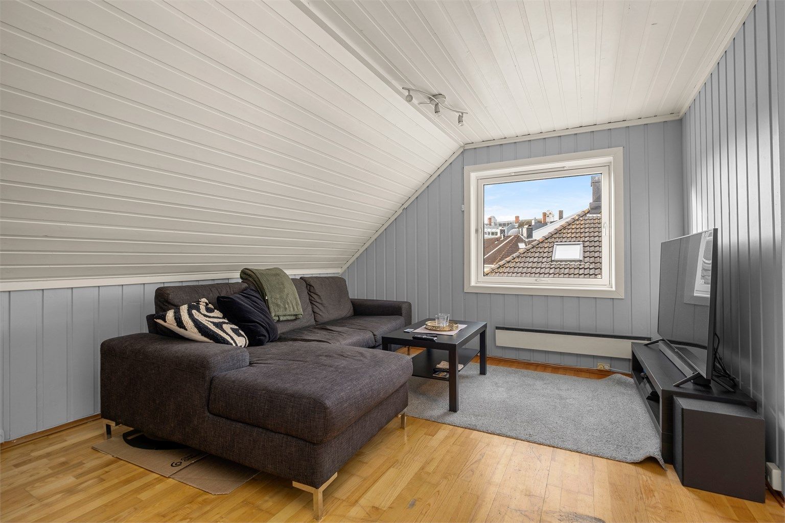 Loftsstuen har en hyggelig stue på 13 kvm med plass til sofa og TV-løsning.