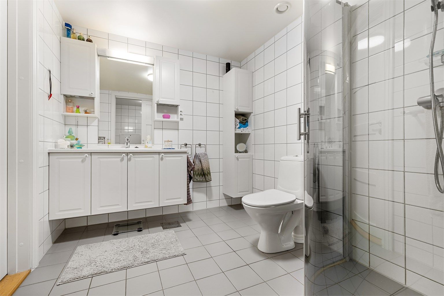 Badet er romslig og fremstår velholdt. Klassiske fargevalg på fliser skaper et tidløst baderom
