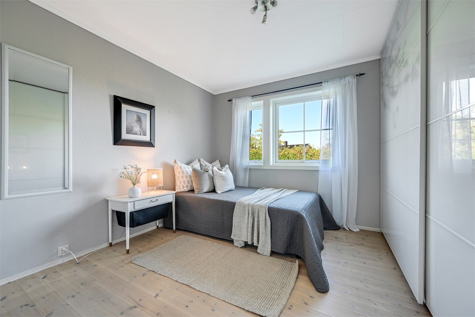 Soverom i 1. etasje innredet med garderobeskap med skyvedører.