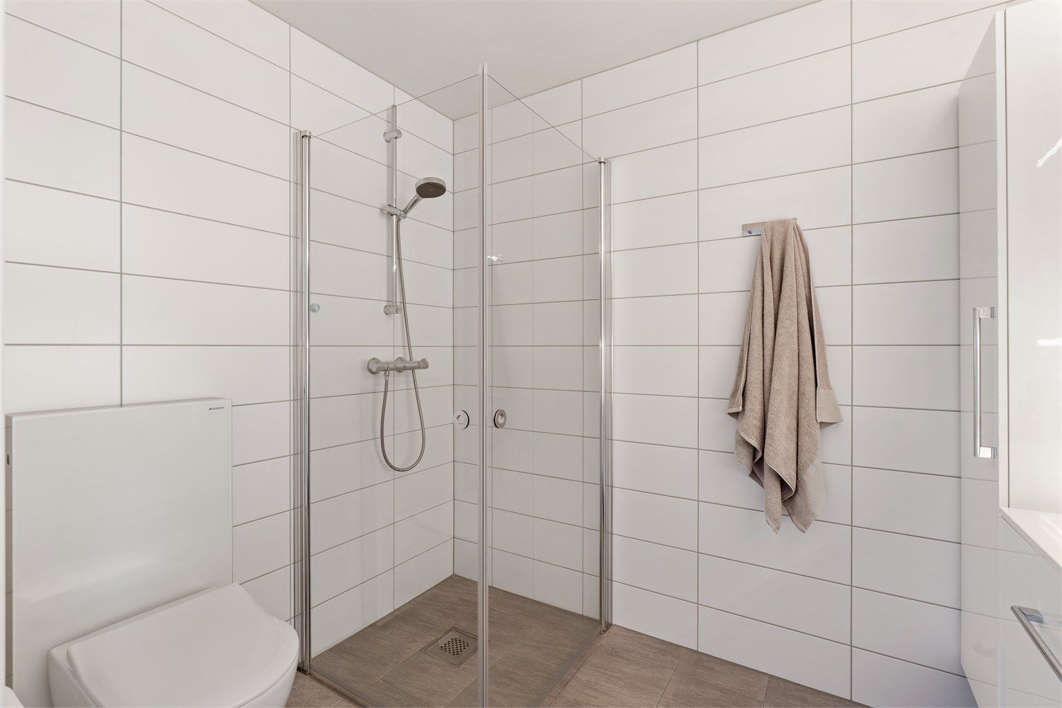 Badet i andre etasje har fliser på gulv og vegger, samt varmekabler.