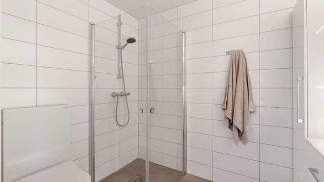 Badet i andre etasje har fliser på gulv og vegger, samt varmekabler.