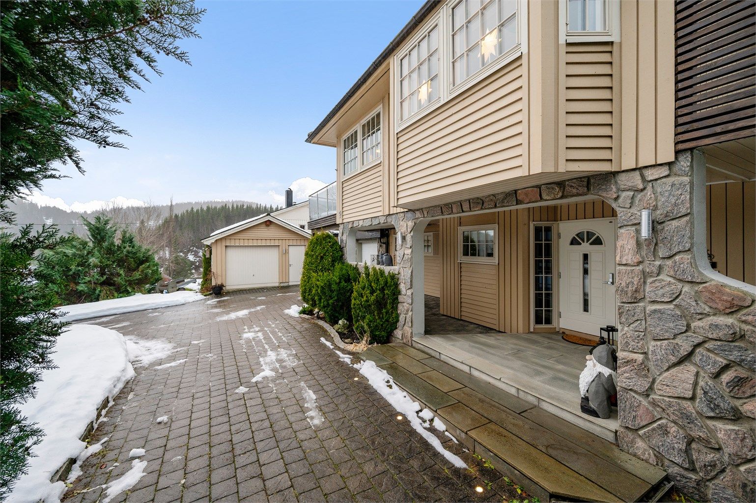 Eiendommen har integrert garasje, frittstående garasje og flere biloppstillingsplasser i gårdsplassen. 