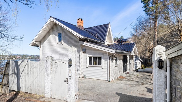 Adkomst til eiendommen via en privat vei, med forstøtningsmurer i naturstein.
